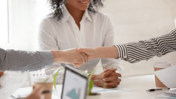 Two people shaking hands after avoiding conflict in the workplace