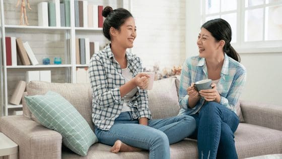 Two-ladies-sat-on-sofa-laughing-good-worklife-balance.png